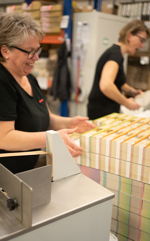 Mitarbeiterin in der Produktion mit Druckbögen